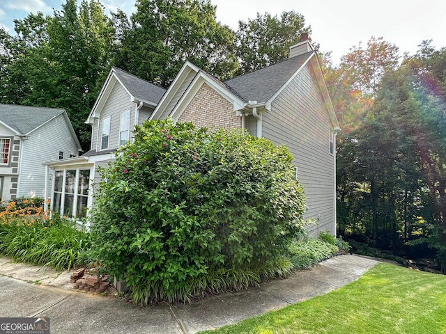 2355 Brick Mill Ct, Duluth, GA 30096 - view of side of home with a chimney, a shingled roof, and a lawn