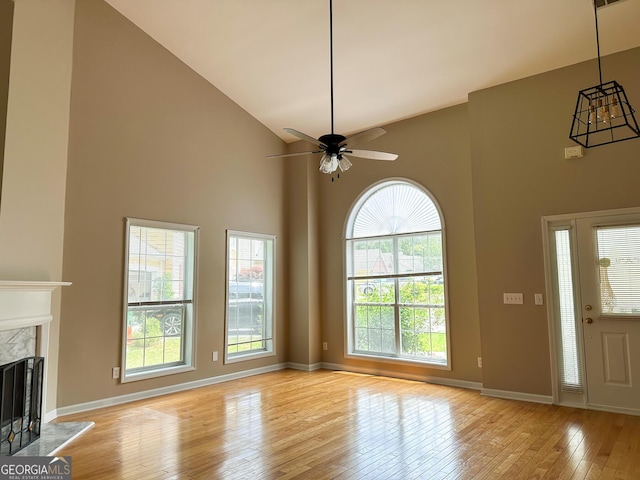 2355 Brick Mill Ct, Duluth, GA 30096 - unfurnished living room with high vaulted ceiling, light wood-style flooring, a premium fireplace, and ceiling fan
