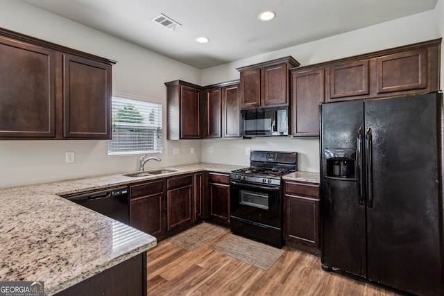 98 Concord Pl, Hiram, GA 30141 - kitchen with black appliances, dark brown cabinets, light wood finished floors, recessed lighting, and light stone countertops