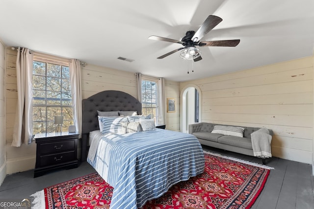 209 Athens St, Jefferson, GA 30549 - bedroom featuring wood walls, multiple windows, a ceiling fan, wood finished floors, and arched walkways