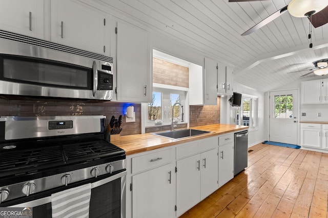 209 Athens St, Jefferson, GA 30549 - kitchen featuring stainless steel appliances, a sink, wooden counters, a ceiling fan, and tasteful backsplash