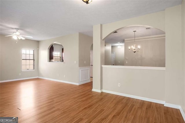 11151 Aliyah Dr, Hampton, GA 30228 - empty room with wood finished floors, ceiling fan, arched walkways, a textured ceiling, and a chandelier