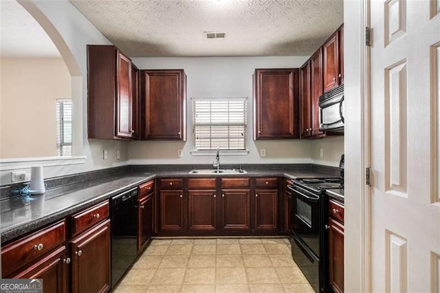11151 Aliyah Dr, Hampton, GA 30228 - kitchen with black appliances, reddish brown cabinets, dark countertops, and a textured ceiling