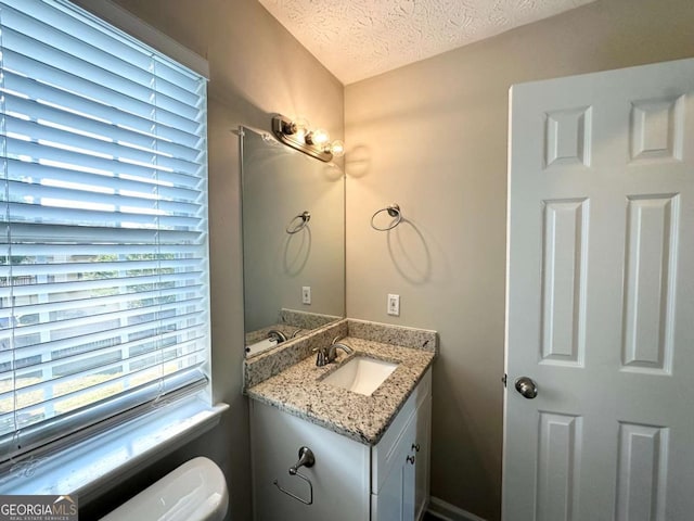 4320 Catalpa Way, Ellenwood, GA 30294 - half bath featuring vanity, a textured ceiling, and toilet