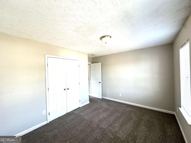 4320 Catalpa Way, Ellenwood, GA 30294 - unfurnished bedroom with baseboards, dark colored carpet, a textured ceiling, and a closet