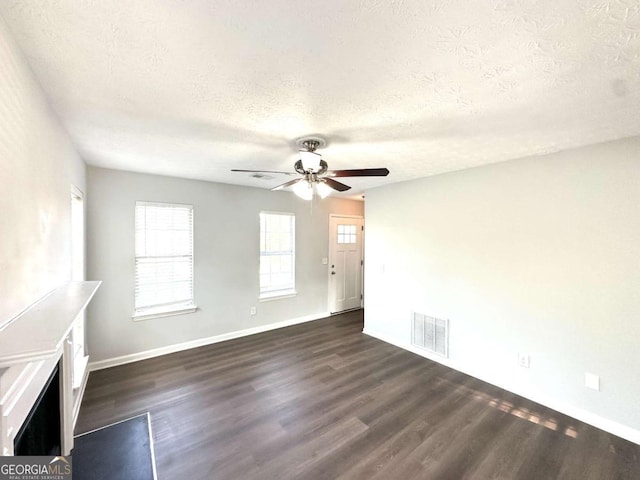 4320 Catalpa Way, Ellenwood, GA 30294 - unfurnished living room featuring a textured ceiling, dark wood-style floors, a ceiling fan, and baseboards