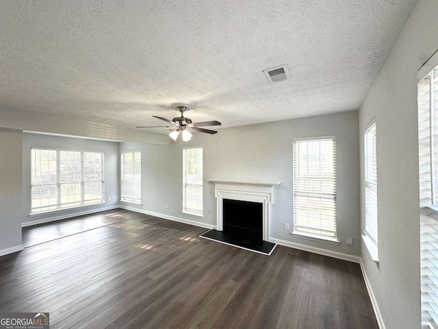 4320 Catalpa Way, Ellenwood, GA 30294 - unfurnished living room with baseboards, dark wood finished floors, a fireplace with raised hearth, ceiling fan, and plenty of natural light