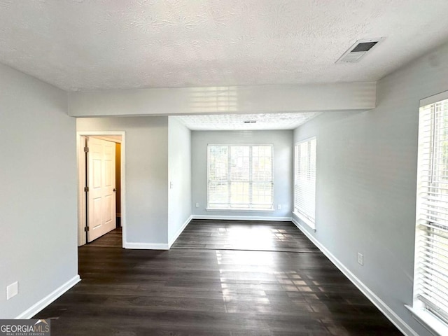 4320 Catalpa Way, Ellenwood, GA 30294 - spare room with baseboards, a textured ceiling, plenty of natural light, and dark wood-type flooring