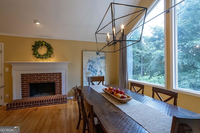 3548 Liberty Ln, Marietta, GA 30062 - dining space featuring wood finished floors, a chandelier, ornamental molding, and a brick fireplace