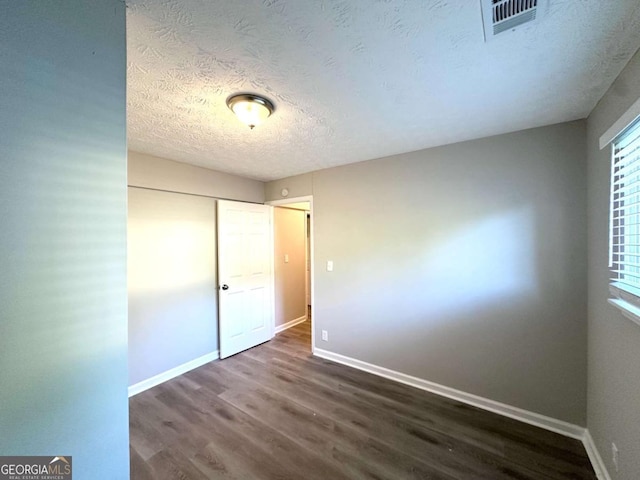 2784 Rockdale Dr, Decatur, GA 30034 - unfurnished bedroom with dark wood-style floors, baseboards, a textured ceiling, and a closet