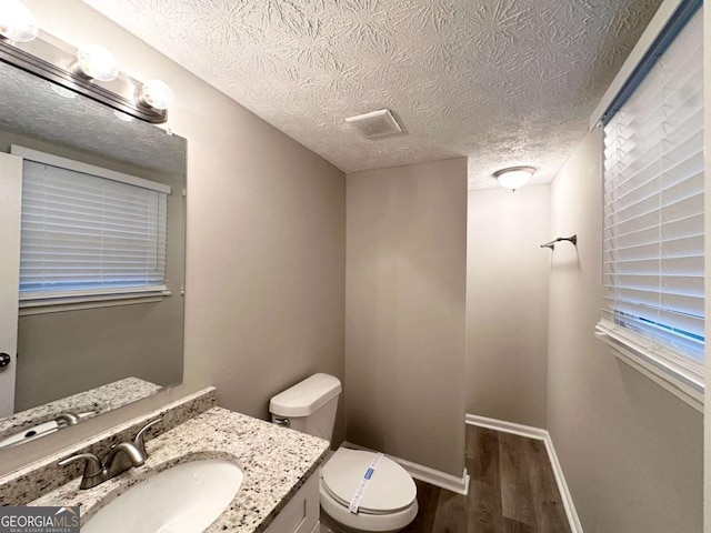 2784 Rockdale Dr, Decatur, GA 30034 - half bathroom featuring wood finished floors, toilet, a textured ceiling, vanity, and baseboards