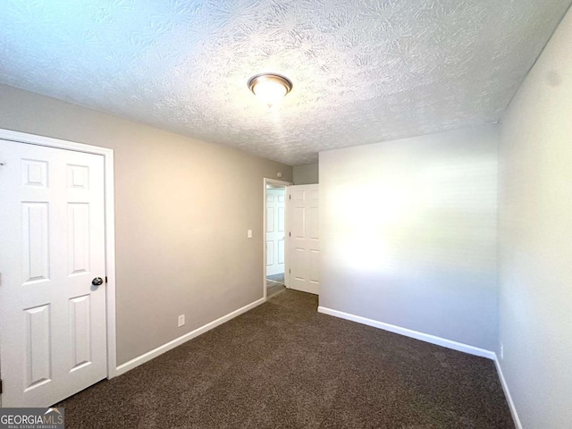 2784 Rockdale Dr, Decatur, GA 30034 - unfurnished bedroom with baseboards, dark carpet, and a textured ceiling