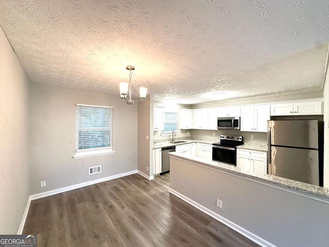 2784 Rockdale Dr, Decatur, GA 30034 - kitchen with stainless steel appliances, a textured ceiling, a sink, dark wood-type flooring, and white cabinets