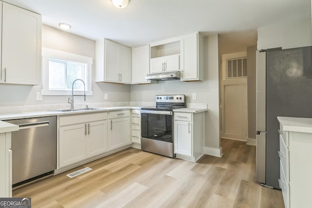 262 Gray Hwy, Gordon, GA 31031 - kitchen with stainless steel appliances, a sink, under cabinet range hood, light countertops, and light wood finished floors