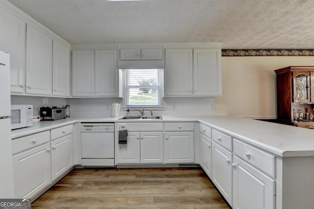 3265 Bold Springs Rd, Dacula, GA 30019 - kitchen with white appliances, a sink, a peninsula, white cabinetry, and a textured ceiling