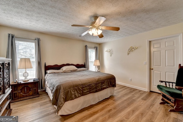 3265 Bold Springs Rd, Dacula, GA 30019 - bedroom with light wood-style floors, ceiling fan, baseboards, and a textured ceiling