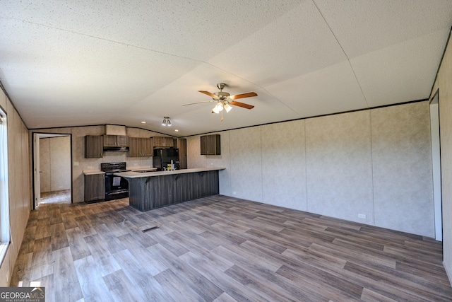 461 Mccord Rd, East Dublin, GA 31027 - kitchen featuring black appliances, a peninsula, a kitchen bar, light countertops, and dark wood finished floors