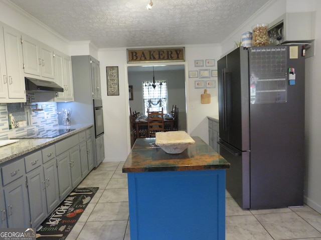 141 Cherokee Cir, Cedartown, GA 30125 - kitchen featuring black appliances, under cabinet range hood, a textured ceiling, a kitchen island, and backsplash