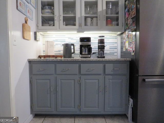 141 Cherokee Cir, Cedartown, GA 30125 - bar area with freestanding refrigerator, light tile patterned floors, and tasteful backsplash