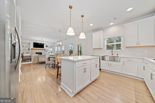 306 Coppergate Ct, Holly Springs, GA 30115 - kitchen featuring stainless steel refrigerator with ice dispenser, a fireplace, open floor plan, a center island, and white cabinetry