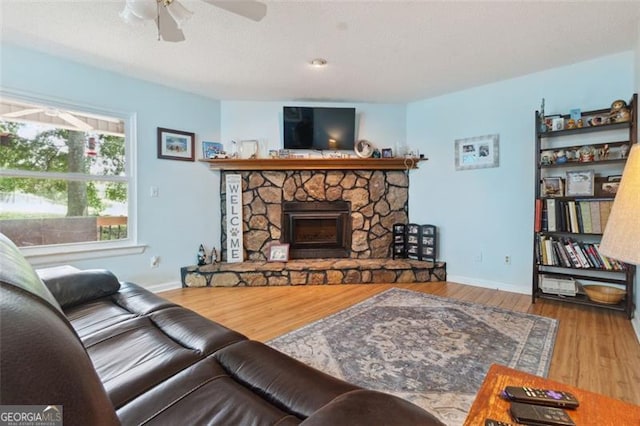 141 Mills Creek Path, Hiram, GA 30141 - living room with ceiling fan, wood finished floors, and a stone fireplace