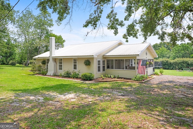 1072 Burtons Ferry Highway, Sylvania, GA 30467 - ranch-style house featuring a chimney, a sunroom, a front yard, and metal roof
