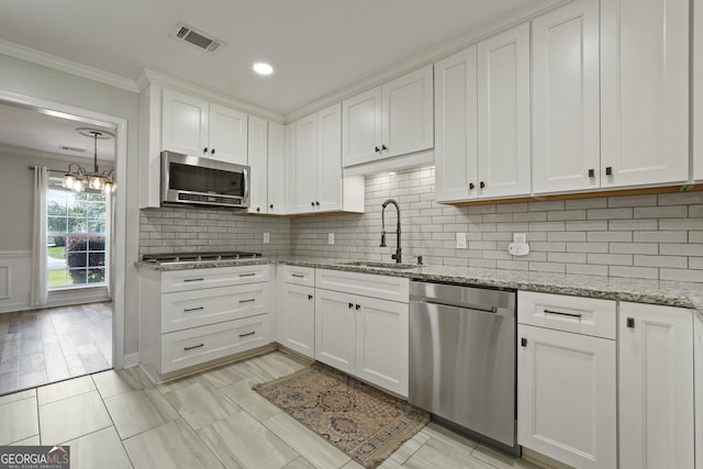 510 Braves Field Dr, Guyton, GA 31312 - kitchen featuring stainless steel appliances, a sink, ornamental molding, white cabinets, and decorative backsplash
