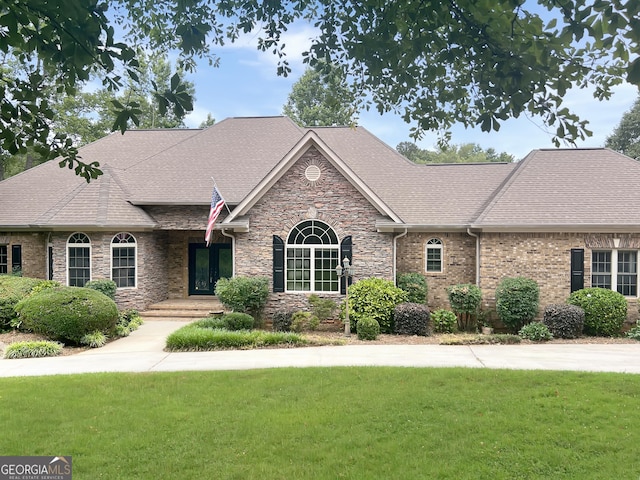 232 Darwish Dr, Mcdonough, GA 30252 - view of front of house featuring a front yard, stone siding, and roof with shingles