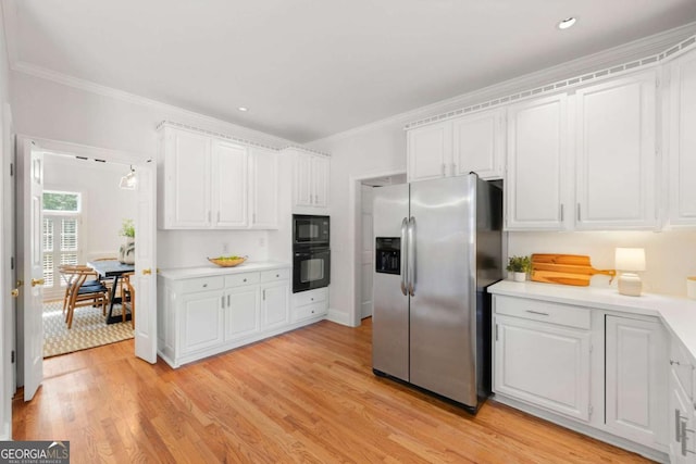 2903 Ashebrooke Dr NE, Marietta, GA 30068 - kitchen featuring black appliances, white cabinets, crown molding, light countertops, and light wood-type flooring