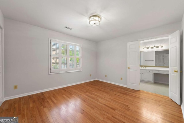 2903 Ashebrooke Dr NE, Marietta, GA 30068 - unfurnished bedroom featuring light wood-type flooring, baseboards, and connected bathroom