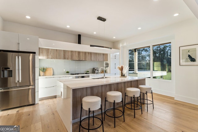 1045 Shepherds Ln NE, Atlanta, GA 30324 - kitchen with stainless steel appliances, modern cabinets, light countertops, light wood-style floors, and tasteful backsplash