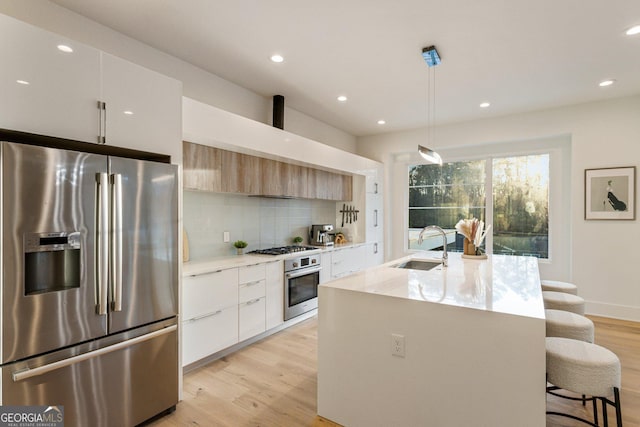 1045 Shepherds Ln NE, Atlanta, GA 30324 - kitchen with stainless steel appliances, modern cabinets, light wood-style floors, backsplash, and a kitchen breakfast bar