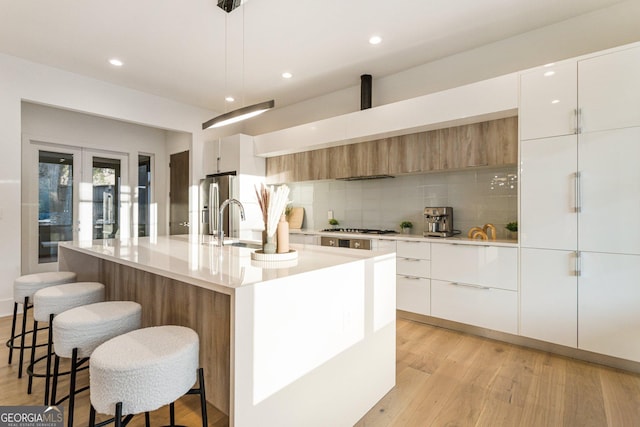 1045 Shepherds Ln NE, Atlanta, GA 30324 - kitchen featuring modern cabinets, light wood-style flooring, backsplash, appliances with stainless steel finishes, and recessed lighting