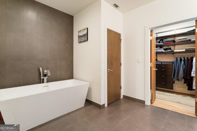 1045 Shepherds Ln NE, Atlanta, GA 30324 - full bathroom with a soaking tub, tile patterned floors, and a walk in closet
