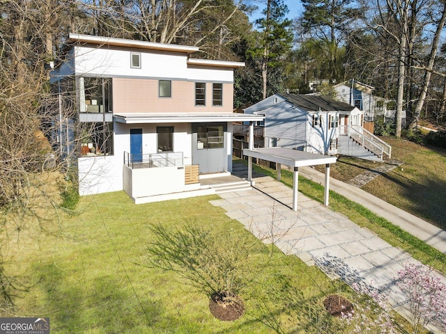 1045 Shepherds Ln NE, Atlanta, GA 30324 - rear view of house featuring concrete driveway, a lawn, view of wooded area, and stucco siding