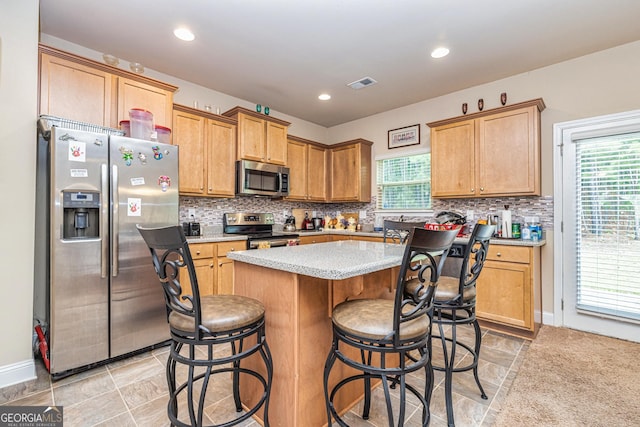 874 Crescent Ln Unit 52, Griffin, GA 30224 - kitchen featuring appliances with stainless steel finishes, a kitchen island, tasteful backsplash, light countertops, and recessed lighting