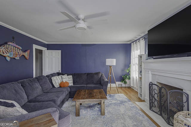 74 Hollis Hts, Newnan, GA 30263 - living room with ceiling fan, light wood finished floors, ornamental molding, and a fireplace with flush hearth