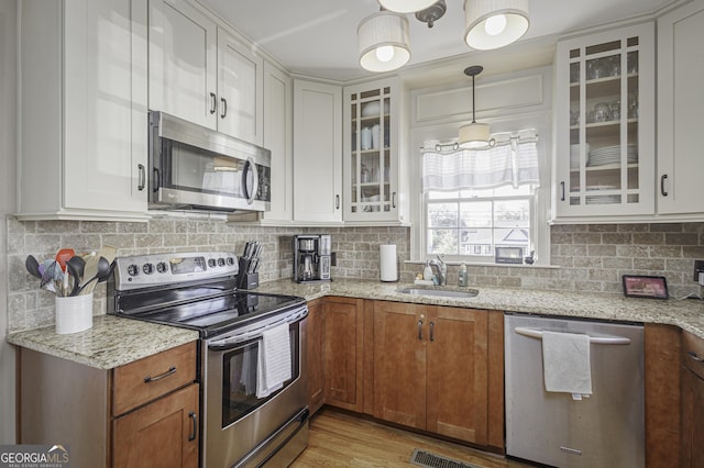 74 Hollis Hts, Newnan, GA 30263 - kitchen featuring stainless steel appliances, white cabinets, glass insert cabinets, and decorative backsplash