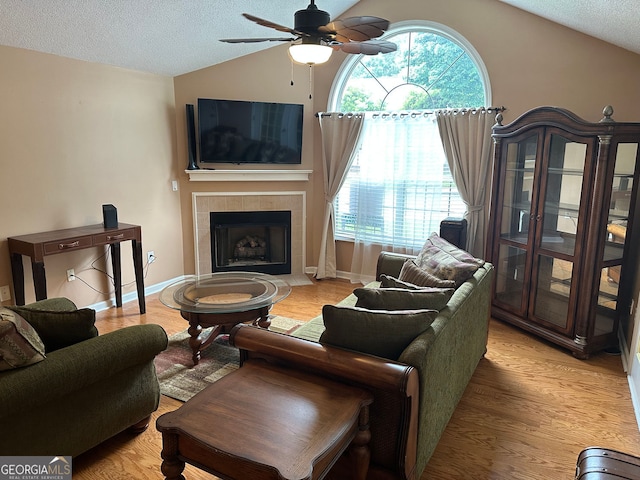 2191 SW Rockbridge Rd Unit 2603, Stone Mountain, GA 30087 - living area with lofted ceiling, a textured ceiling, a ceiling fan, a fireplace, and plenty of natural light