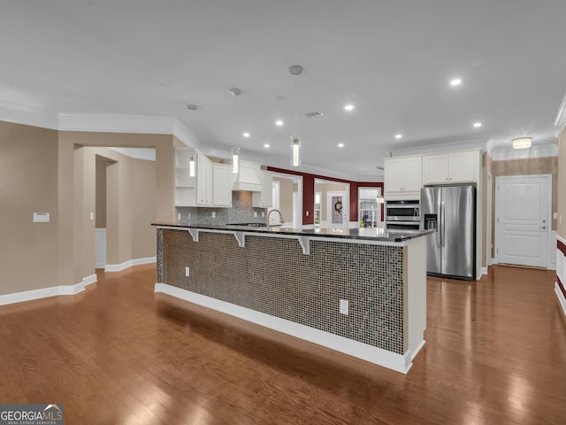 302 Burberry Ct, Griffin, GA 30223 - kitchen with appliances with stainless steel finishes, crown molding, a breakfast bar, dark wood-type flooring, and dark countertops