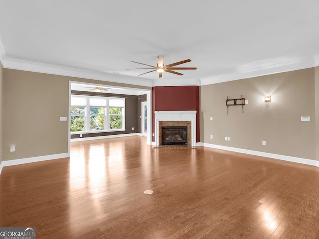 302 Burberry Ct, Griffin, GA 30223 - unfurnished living room featuring a ceiling fan, crown molding, a fireplace, baseboards, and wood finished floors