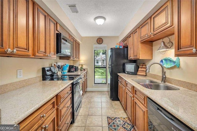 2510 Demere Rd Unit 7, Saint Simons, GA 31522 - kitchen featuring black appliances, brown cabinets, a sink, a textured ceiling, and light tile patterned flooring