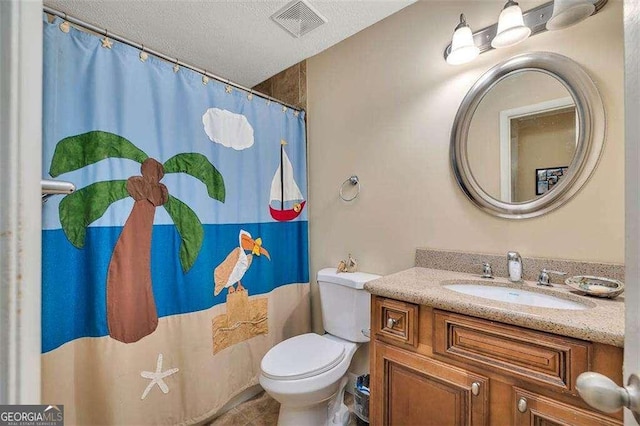 2510 Demere Rd Unit 7, Saint Simons, GA 31522 - full bathroom with toilet, vanity, curtained shower, tile patterned flooring, and a textured ceiling