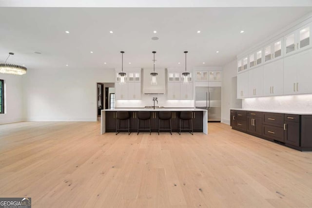 245 Traditions Dr, Alpharetta, GA 30004 - kitchen featuring built in fridge, light wood-style flooring, a kitchen breakfast bar, light countertops, and recessed lighting