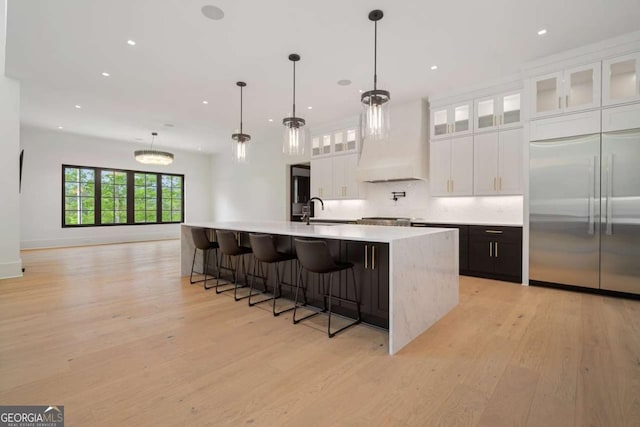 245 Traditions Dr, Alpharetta, GA 30004 - kitchen with stainless steel built in refrigerator, light wood-style floors, light countertops, recessed lighting, and a large island