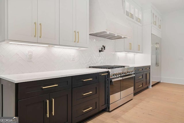 245 Traditions Dr, Alpharetta, GA 30004 - kitchen with high quality appliances, custom exhaust hood, white cabinets, light wood-style flooring, and light countertops