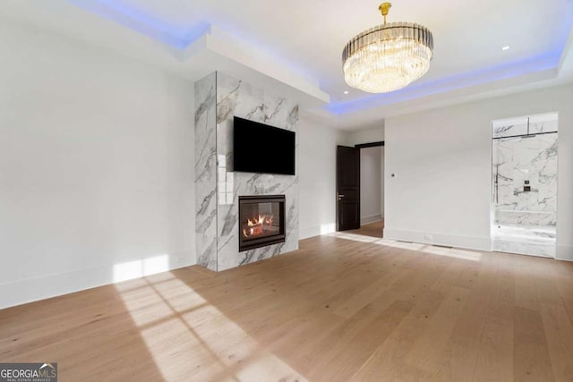 245 Traditions Dr, Alpharetta, GA 30004 - unfurnished living room with a raised ceiling, wood finished floors, and a chandelier