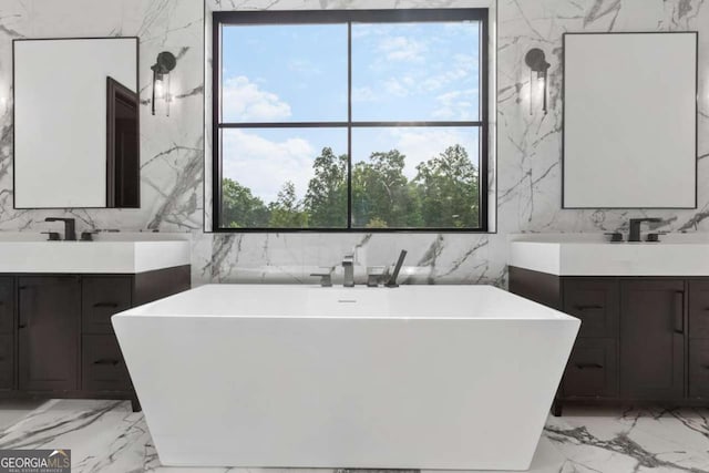 245 Traditions Dr, Alpharetta, GA 30004 - full bathroom featuring marble tiled flooring, stone wall, two vanities, and a soaking tub