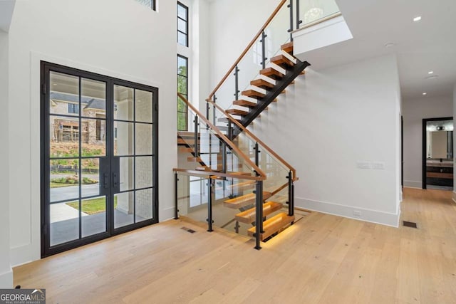 245 Traditions Dr, Alpharetta, GA 30004 - entrance foyer with french doors, wood finished floors, stairs, and a towering ceiling