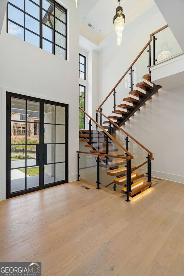 245 Traditions Dr, Alpharetta, GA 30004 - foyer entrance featuring a towering ceiling, hardwood / wood-style flooring, french doors, stairs, and a chandelier